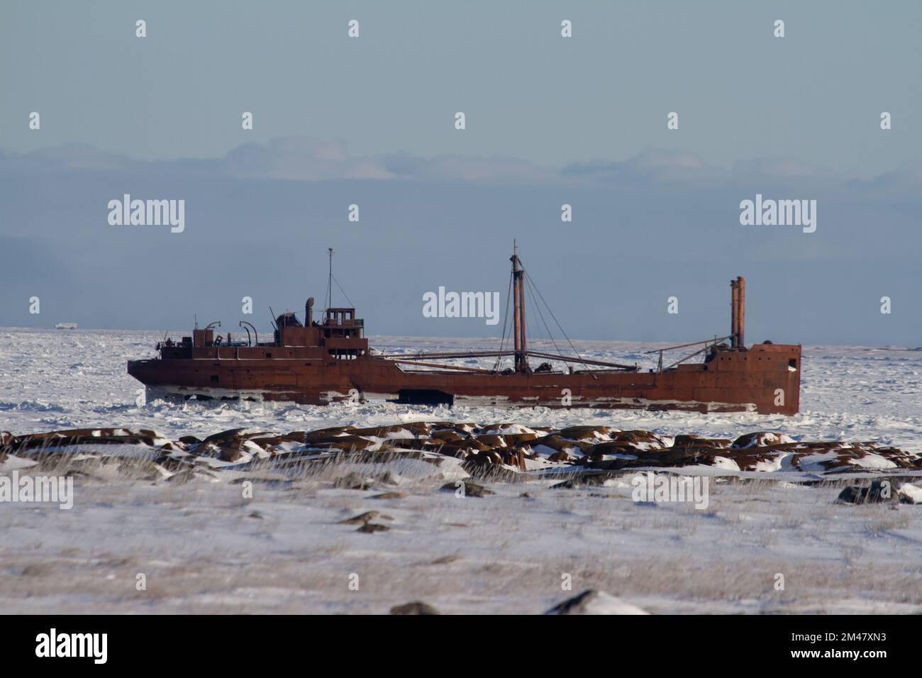 The 80-metre-long wreck of the MV Ithaca sits just outside Bird Cove, 19 kilometres or 12 miles east of Churchill, high and dry when the tide is low and completely surrounded by water at high tide. Stock Photo