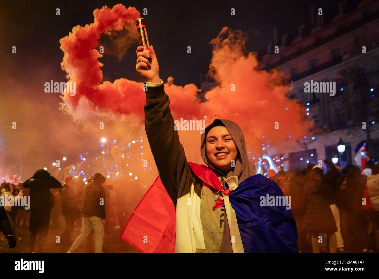 Paris, France. 19th Dec, 2022. A football fan raises a red smoke in support of the French football team. French football fans gather on the Champs Elysees, Paris, to support their national team which they play against Argentina during the final of the FIFA World Cup Qatar 2022 on December 18, 2022. Argentina ultimately is crowned as the winner after winning 4-2 in penalties even though the two teams reach a draw 3-3 in extra time. Credit: SOPA Images Limited/Alamy Live News Stock Photo
