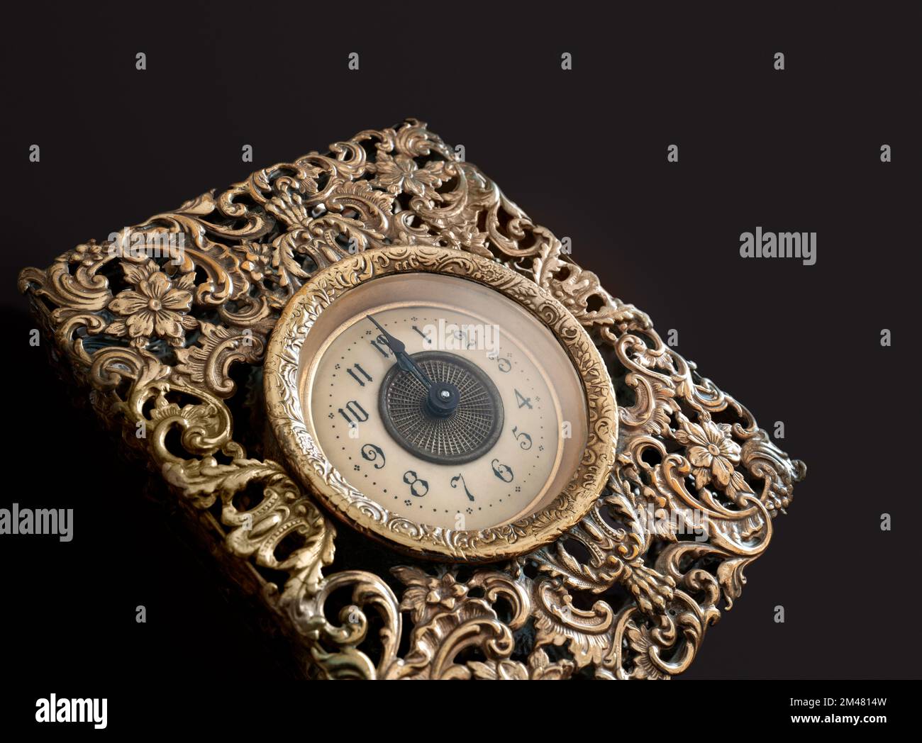 Close up view of vintage english bronze clock pointing midnight. New year twelve o'clock concept. Stock Photo