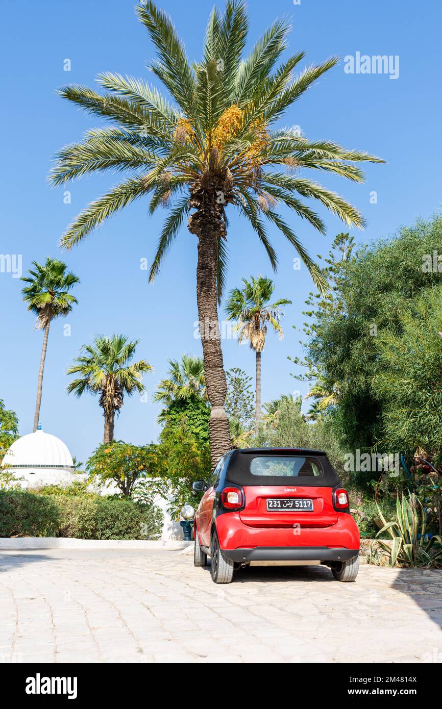 Rear view of a red smart Fortwo car in the hotel parking on a beautiful sunny day. Stock Photo