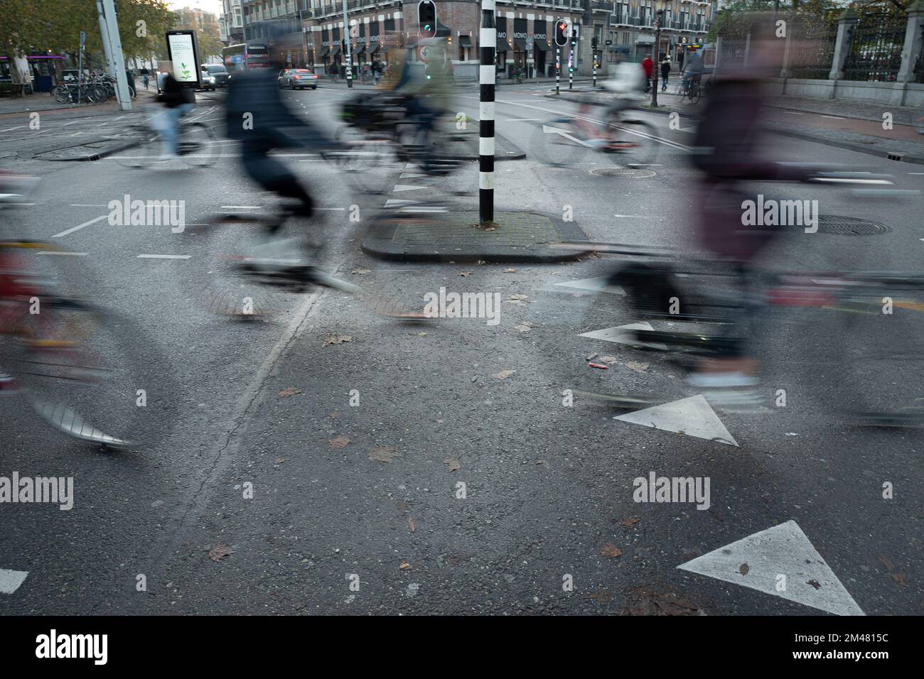 Amsterdam- Holland- Circa November 2019. Blurred cyclists in motion crossing streets of Amsterdam downtown. Bicycle congestion on the streets Stock Photo