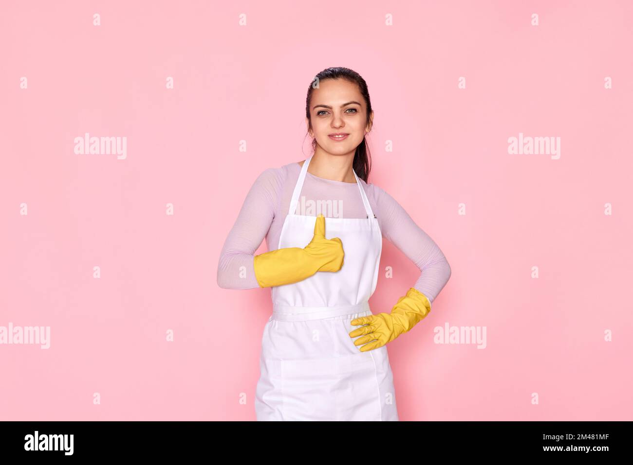 woman in gloves and cleaner apron showing ok sign Stock Photo - Alamy