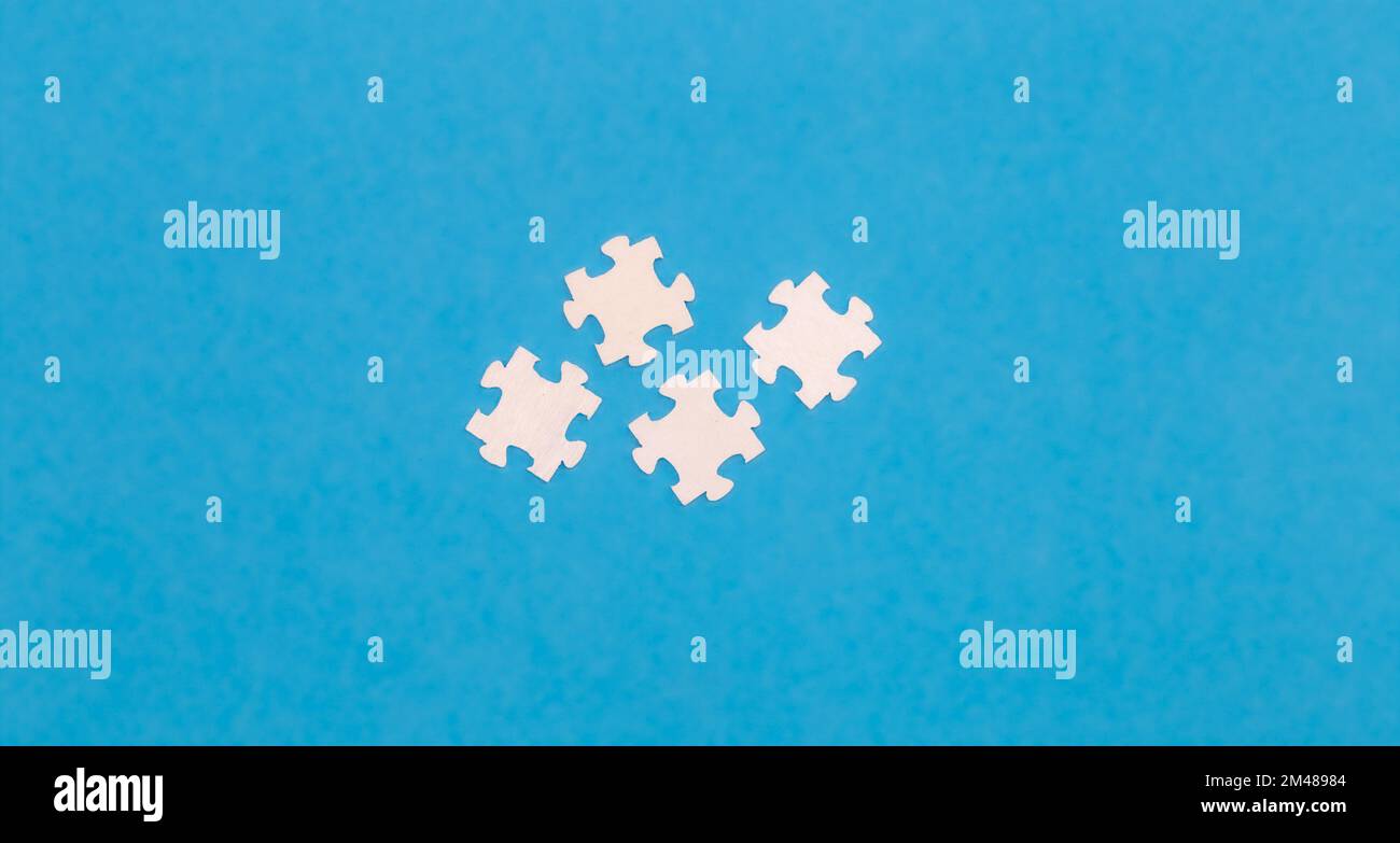 White puzzles on a blue background, flat lay. Stock Photo
