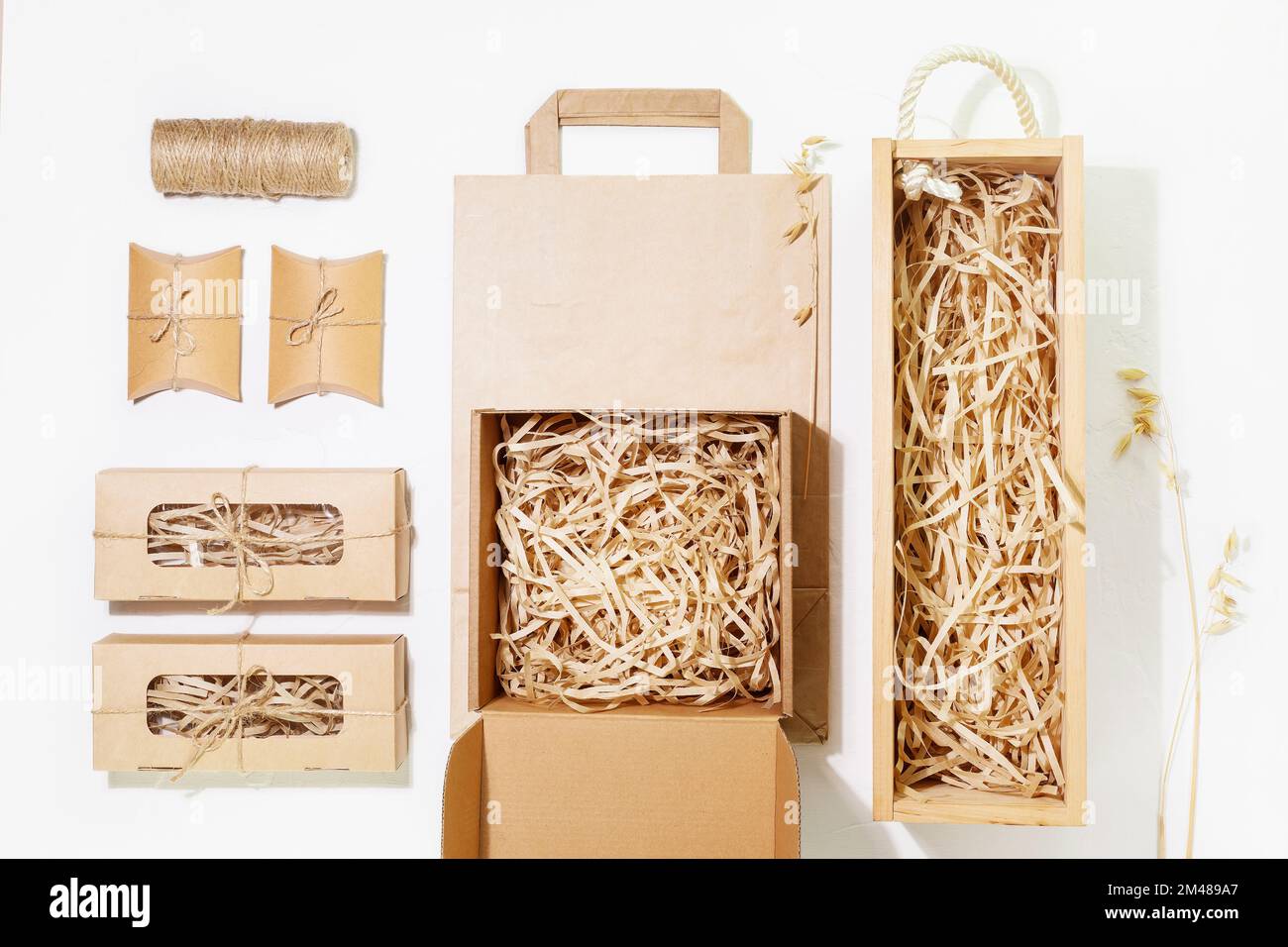 Eco friendly packaging concept. Set of cardboard boxes with shredded paper inside, paper bag and small gift boxes for packaging goods from online stor Stock Photo