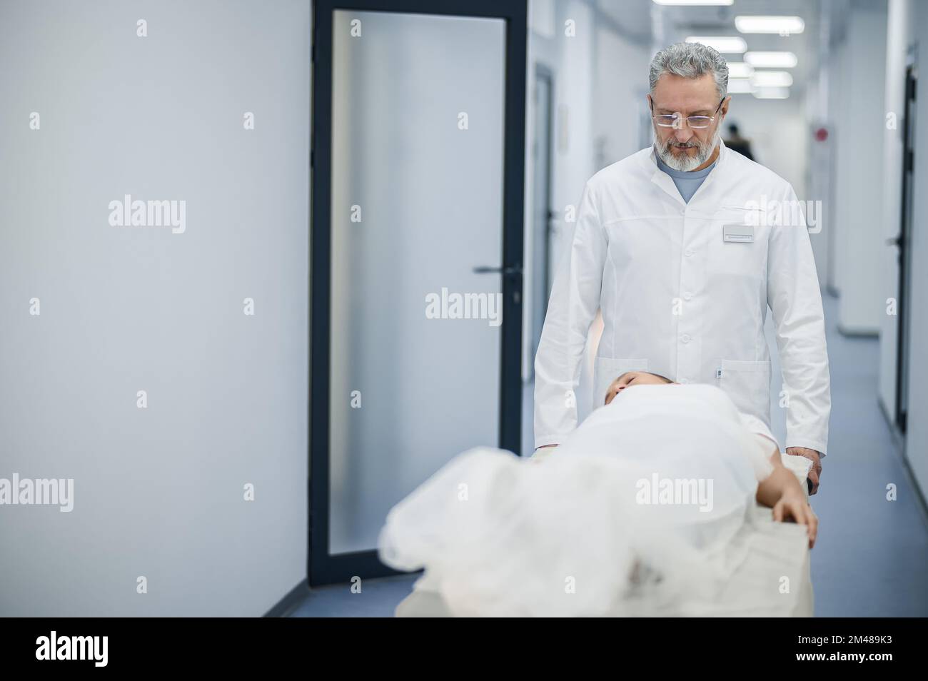 A mature doctor carrying the gurney with a patient Stock Photo Alamy