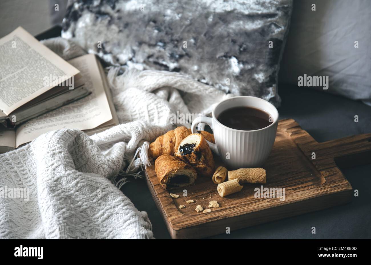 Cozy composition with a cup of tea, candles and books in bed Stock ...