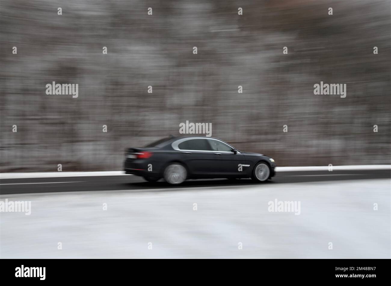 Car panning. Road beside woods. Speed around 60m/h. Stock picture. Stock Photo
