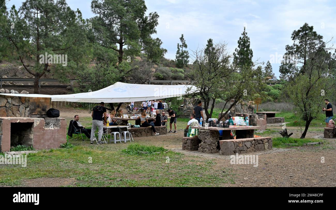 Families in public picnic area with barbecues, hiking trails nearby in the San Bartolomé de Tirajana valley near village of Fataga, Gran Canaria Stock Photo