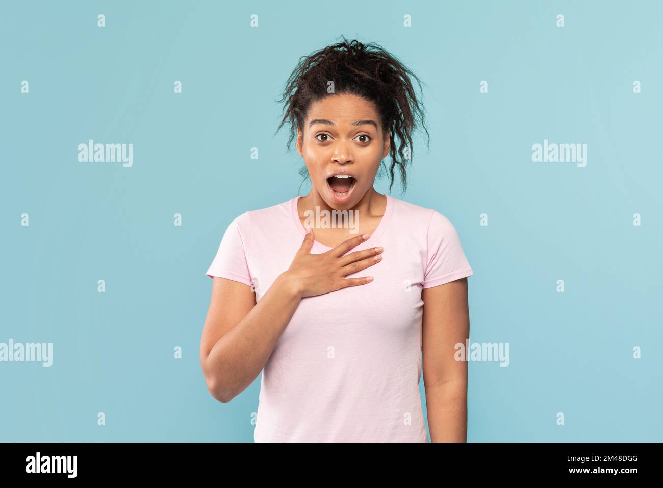 Shocked black lady touching chest and looking at camera in surprise over blue background, amazing promo Stock Photo