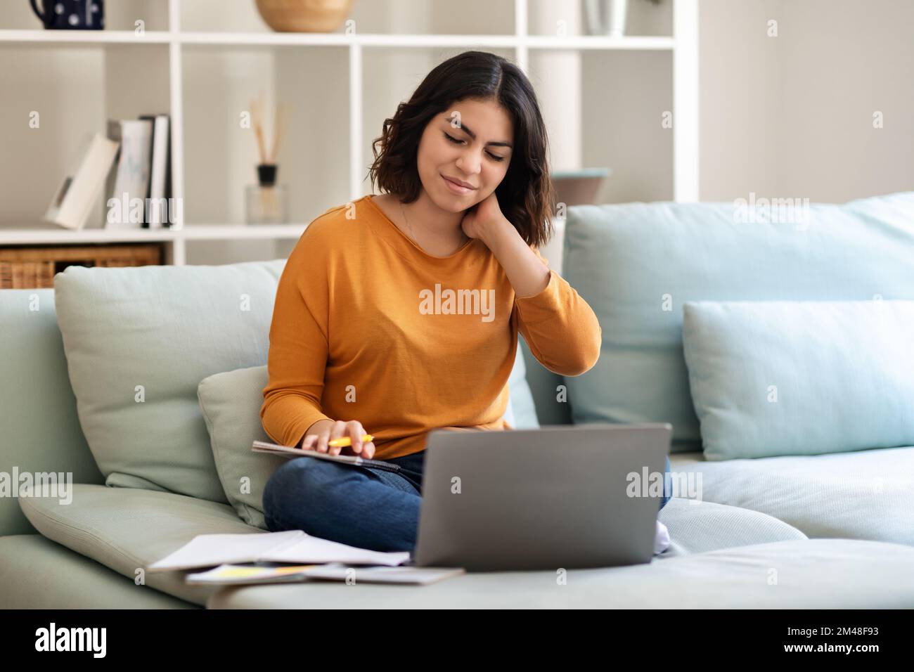 Young Arab Woman Suffering Neck Pain While Working With Laptop At Home Stock Photo