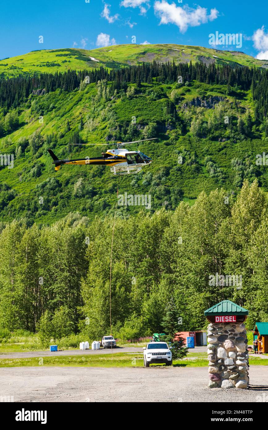 Helicopter doing lift transport; Bell 2 Lodge; Stewart-Cassiar Highway; Oweegee Range; British Columbia; Canada Stock Photo