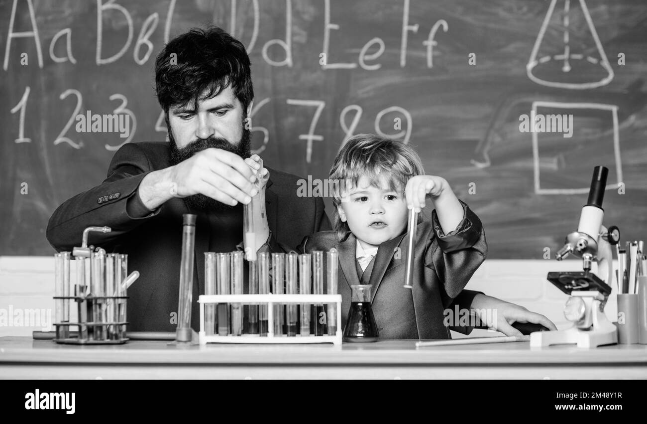 More Intelligence Solutions. man with little boy. Chemistry beaker experiment. father and son