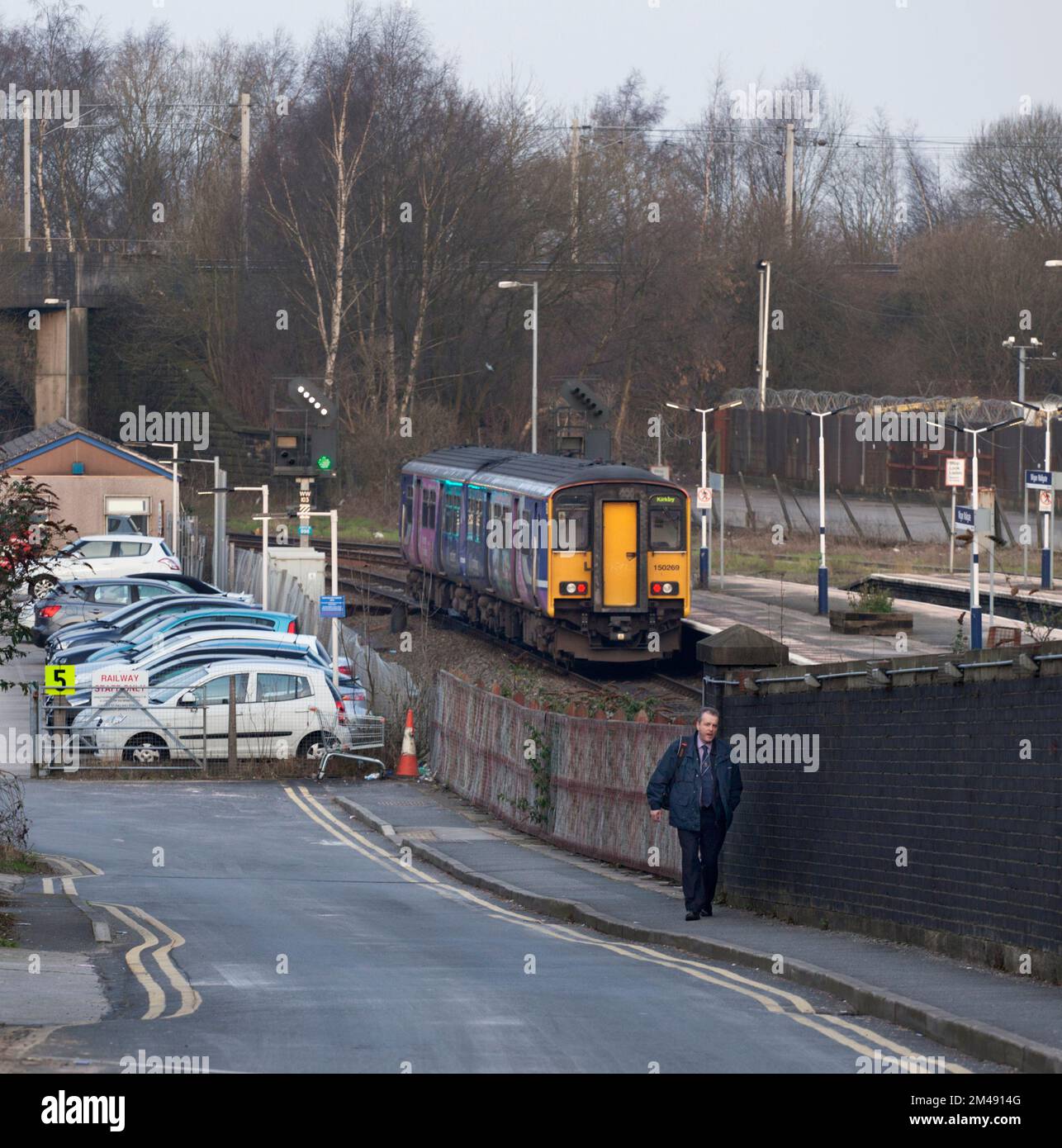 Northern Rail class 150 sprinter train at Wigan Wallgate with the staff car park and a member of Northern Rail staff Stock Photo