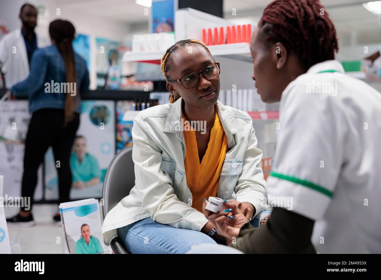 African american pharmacist using pulse oximeter, measuring patient