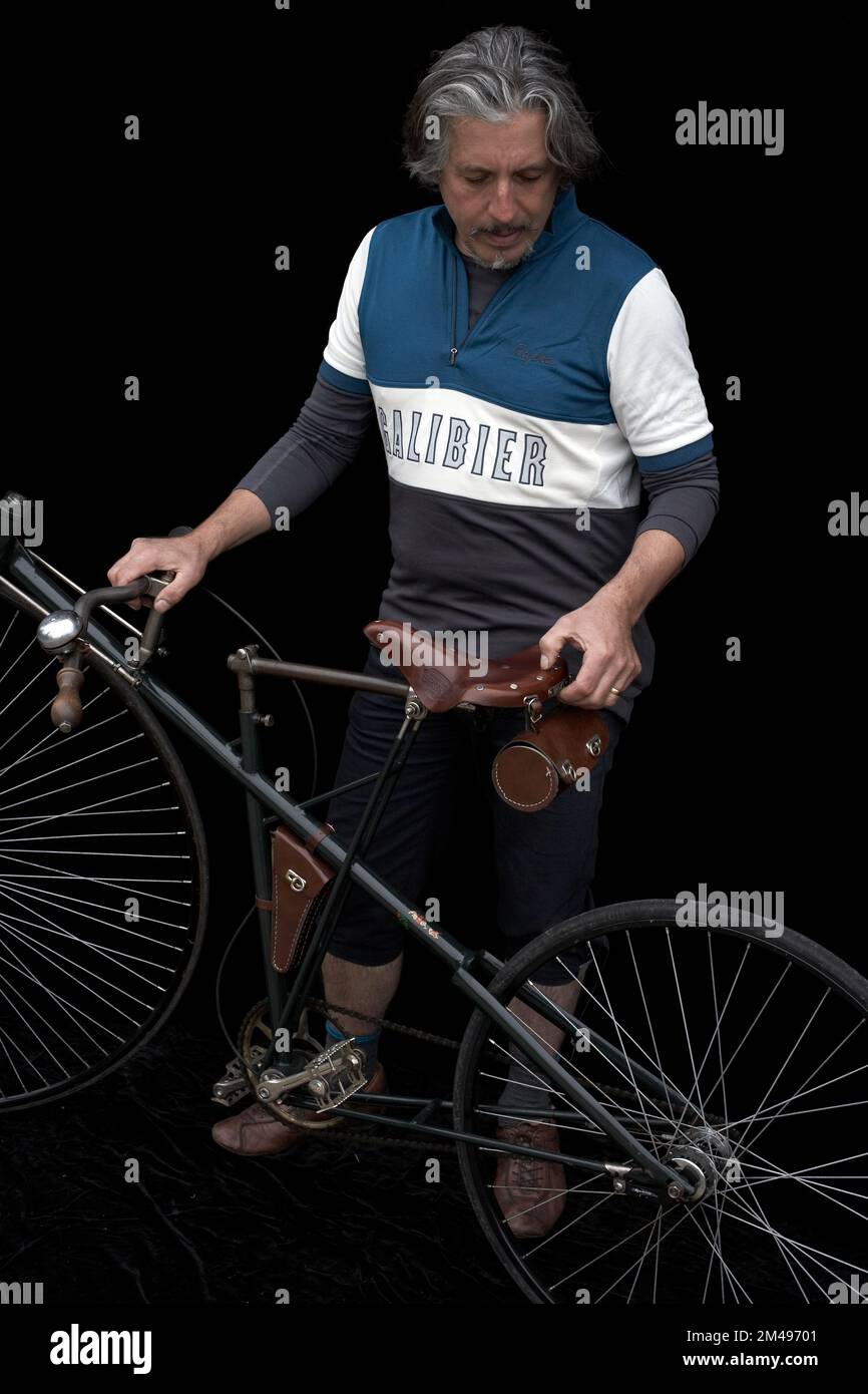 bicycle collector with vintage historic retro bicycle and black background Stock Photo