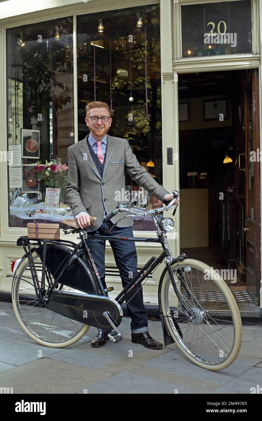 Man dressed in suit standing beside bicycle stock photo alamy