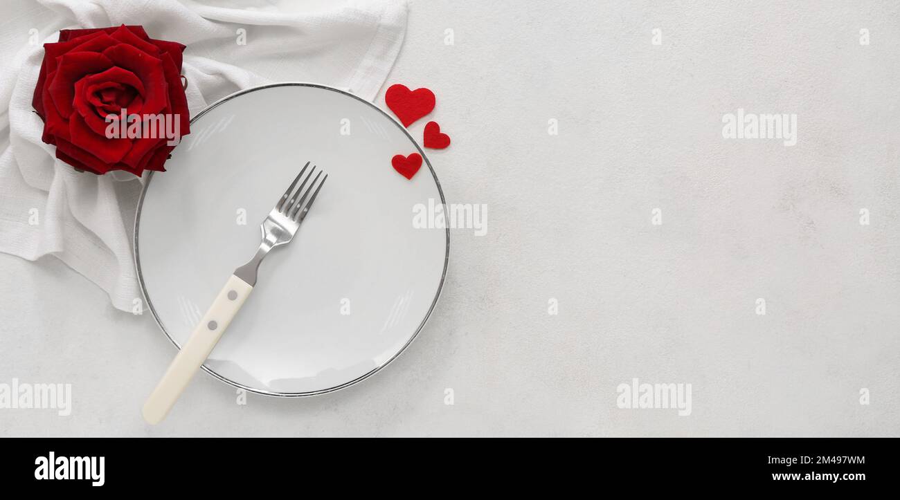 Table setting for Valentine's Day with red hearts and rose flower on ...