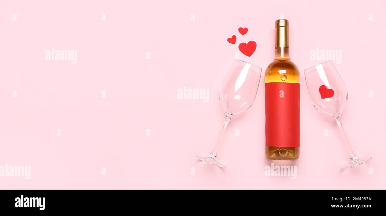 Bottle of wine, glasses and hearts on pink background with space for ...