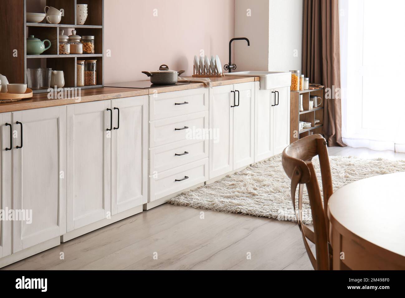 Interior of light modern kitchen with white counters Stock Photo - Alamy