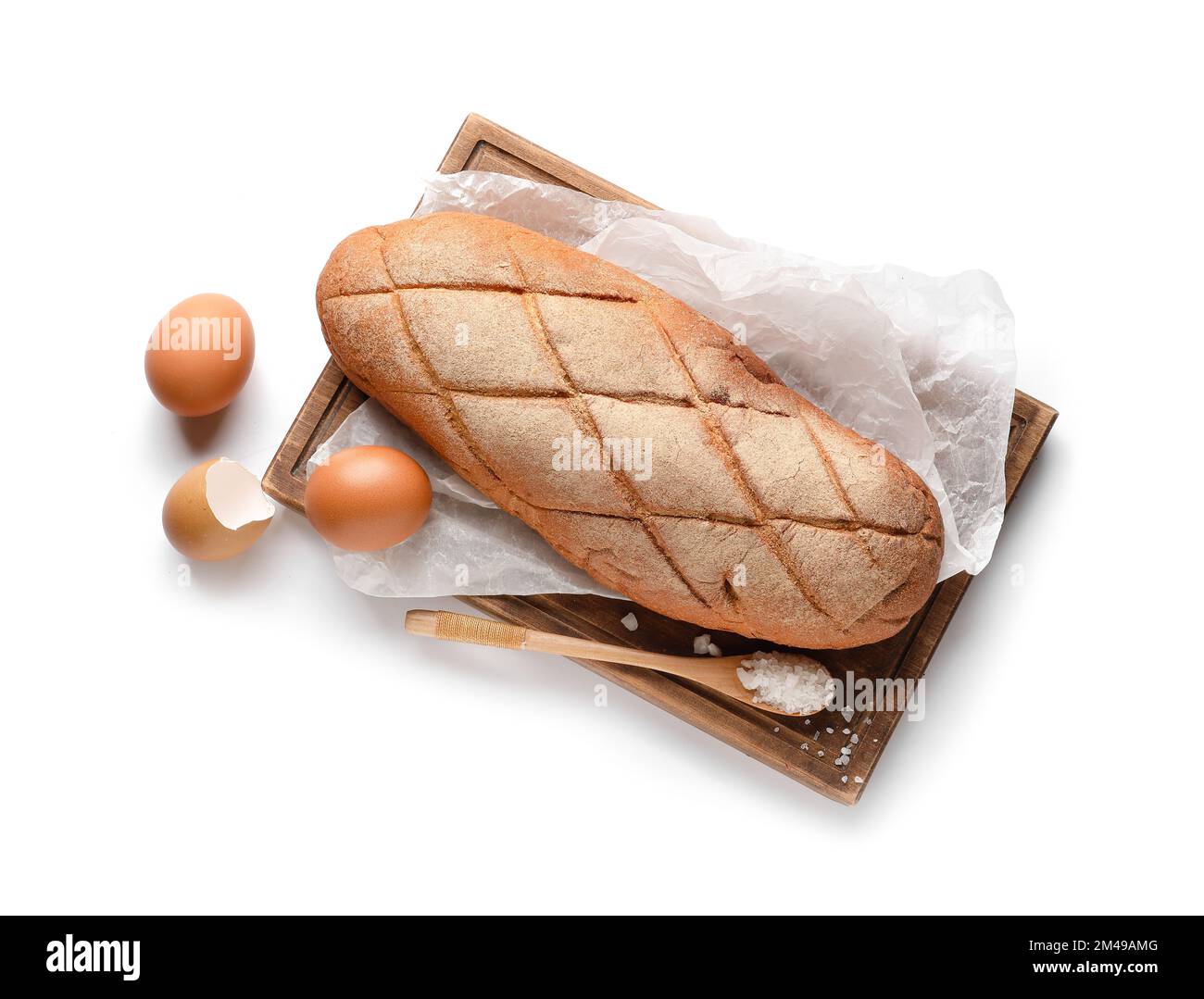 Wooden board with loaf of fresh bread and eggs on white background ...