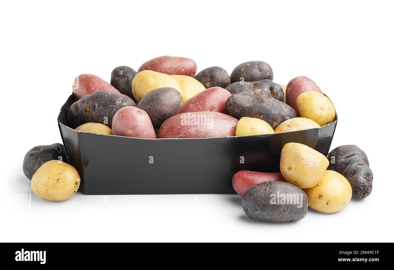 Cardboard box with different types of raw potatoes on white background