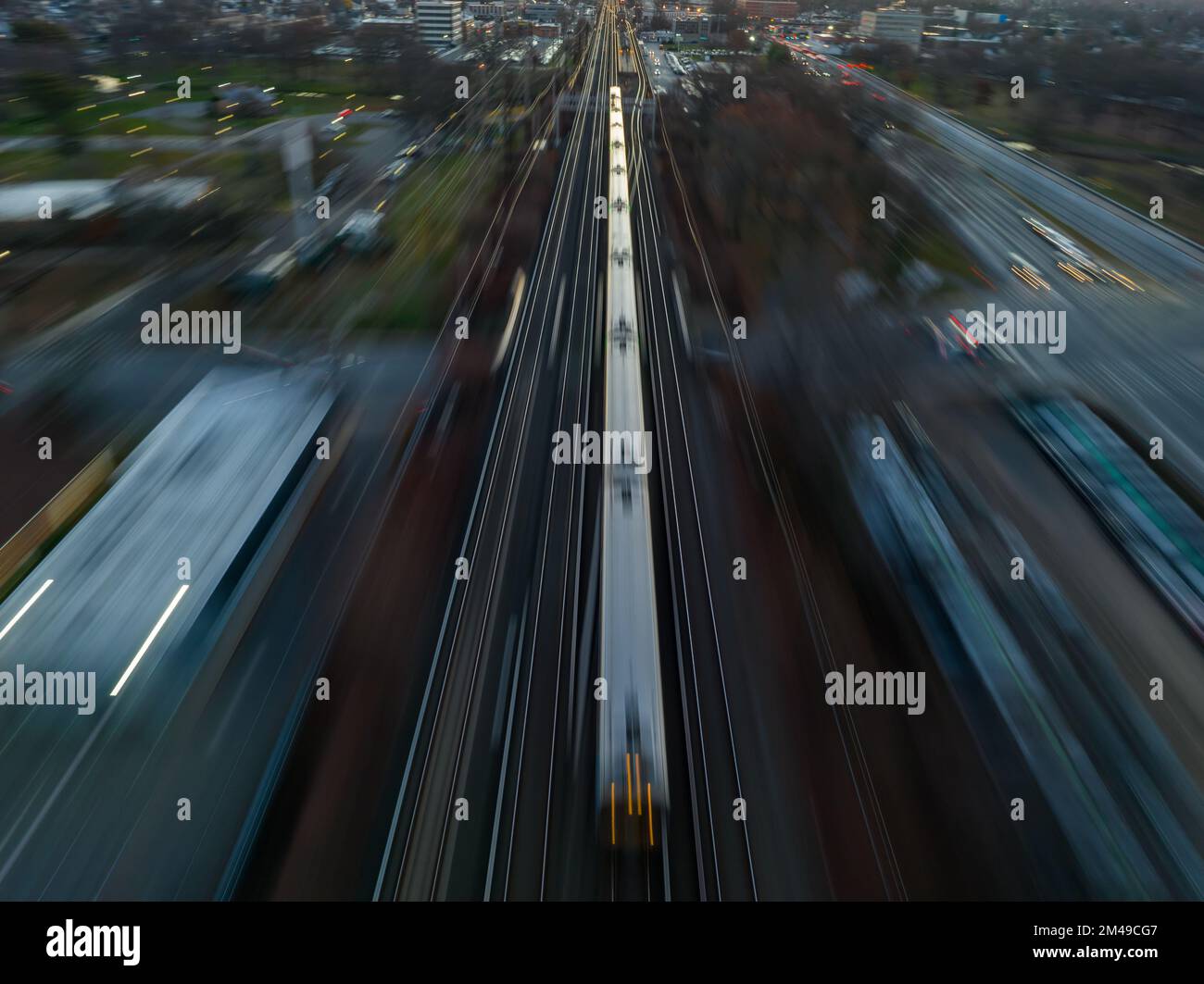 An aerial view of a high-speed train in motion on tracks in the city ...