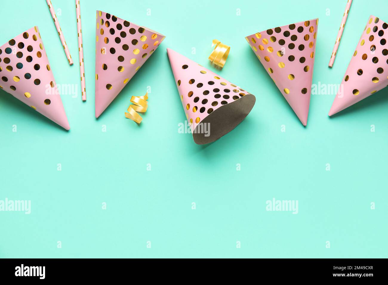 Party hats, confetti and straws on blue background Stock Photo - Alamy