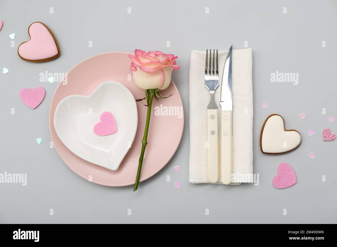 Table setting for Valentine's Day with pink rose on grey background ...