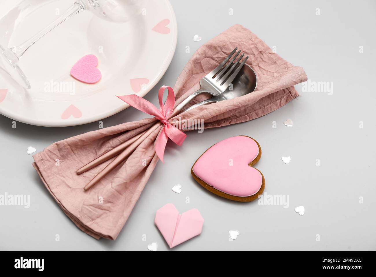 Table setting for Valentine's Day with pink hearts on grey background ...