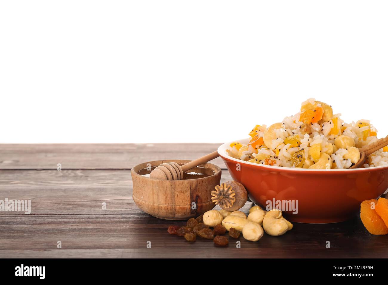 Bowl of rice Kutya and ingredients on table against white background