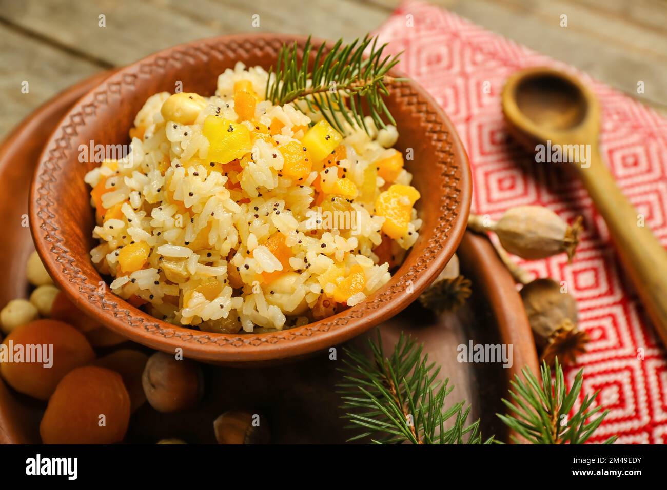 Tray with bowl of rice Kutya and Christmas branches on wooden table