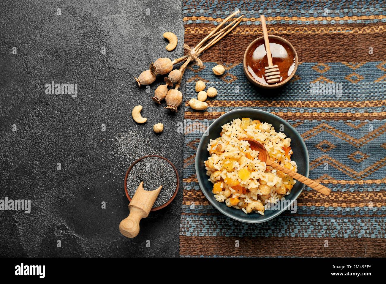 Bowl of rice Kutya, ingredients and poppy pods on dark background Stock