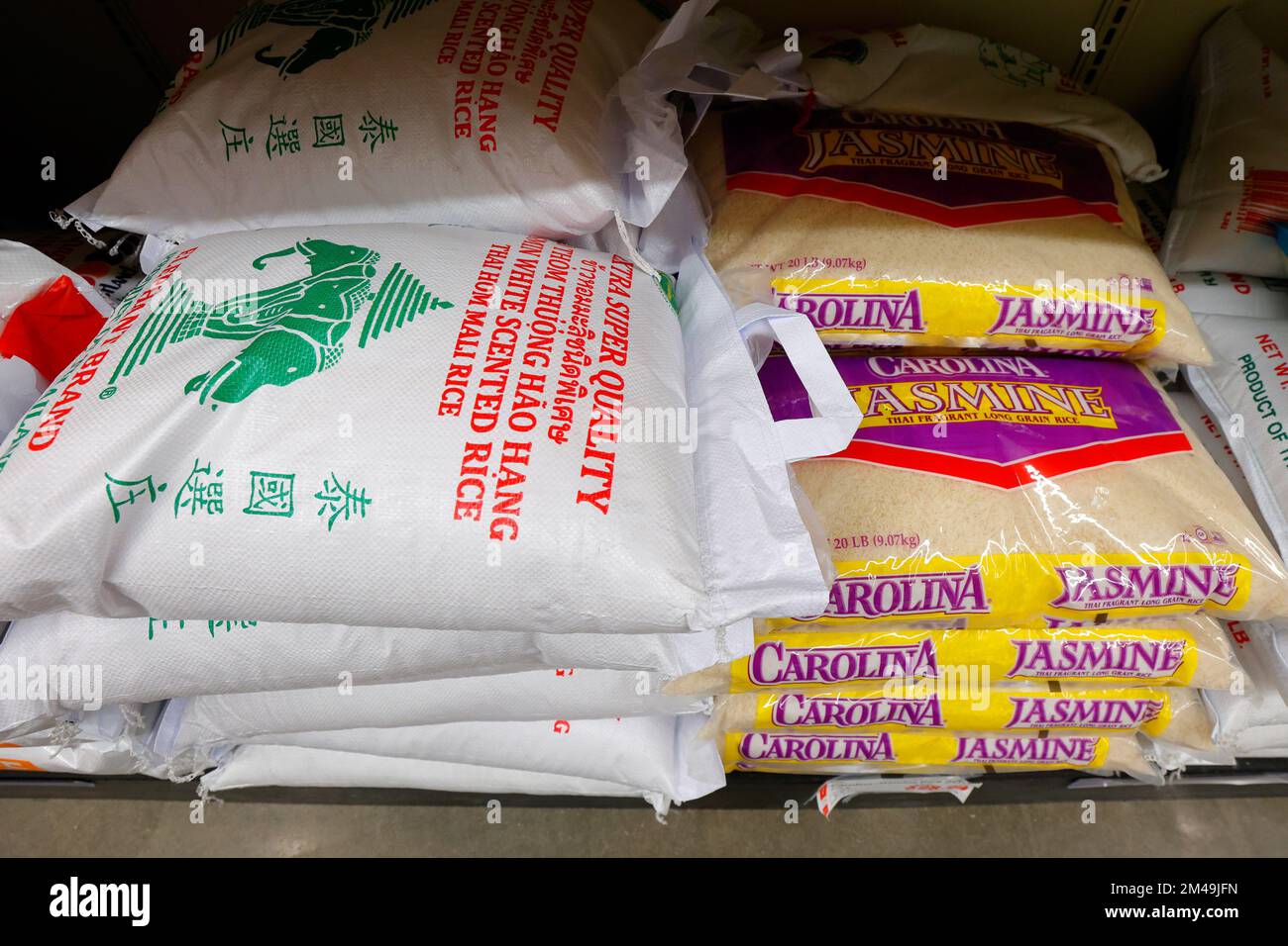 Sacks of Three Elephant, and Carolina Jasmine rice on a supermarket shelf in an Asian grocery store. Stock Photo