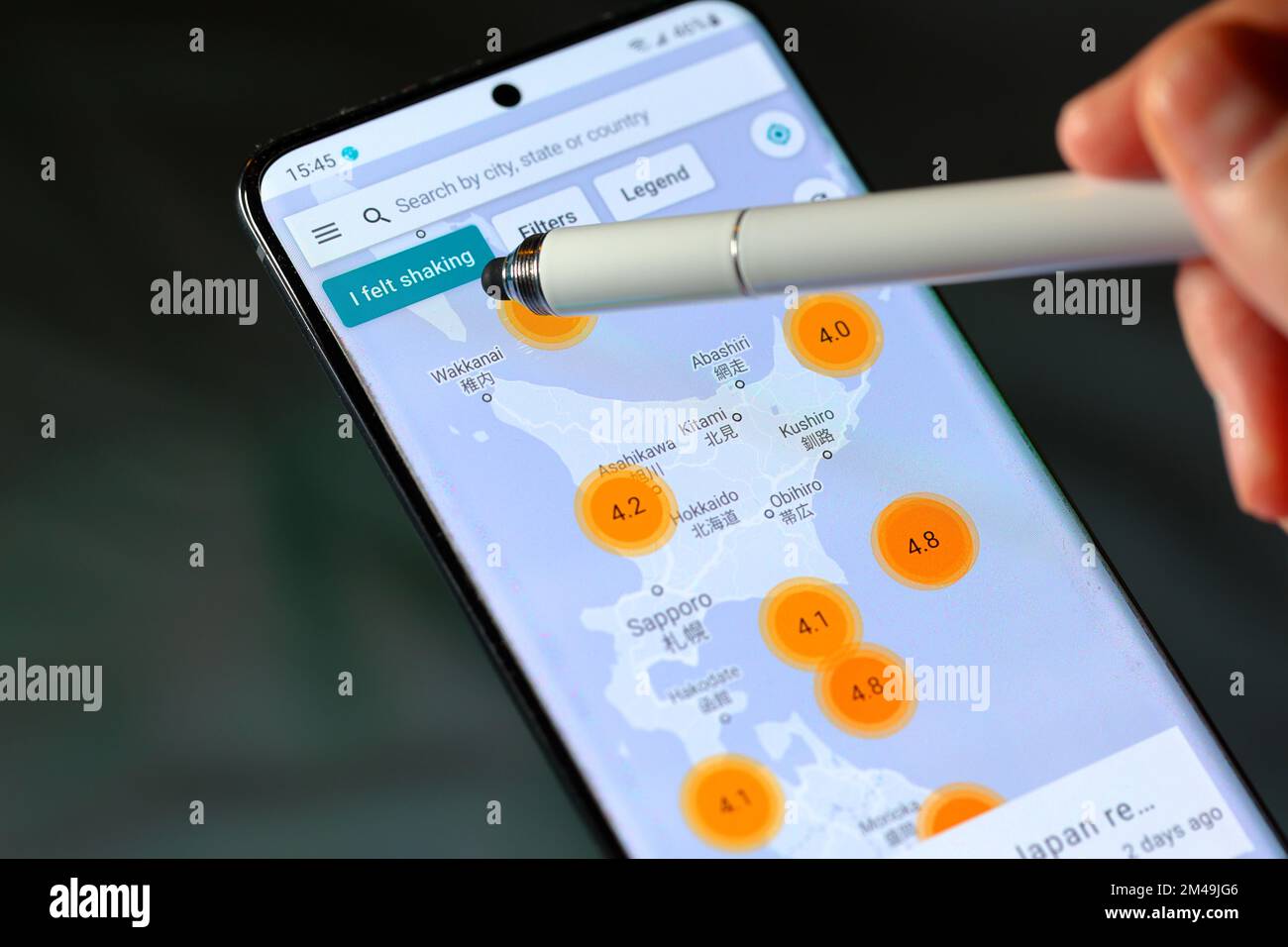 A stylus points to the 'I felt shaking' button on the MyShake earthquake app by UC Berkeley Seismological Lab. Stock Photo