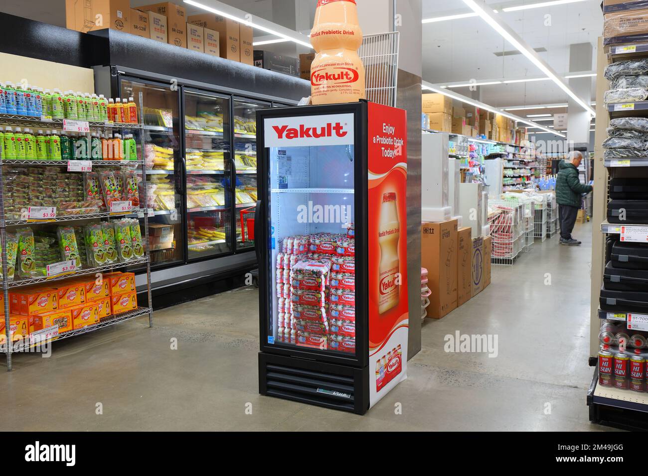 A mini refrigerator stocked with Yakult probiotic yogurt drink in an Asian supermarket. Stock Photo