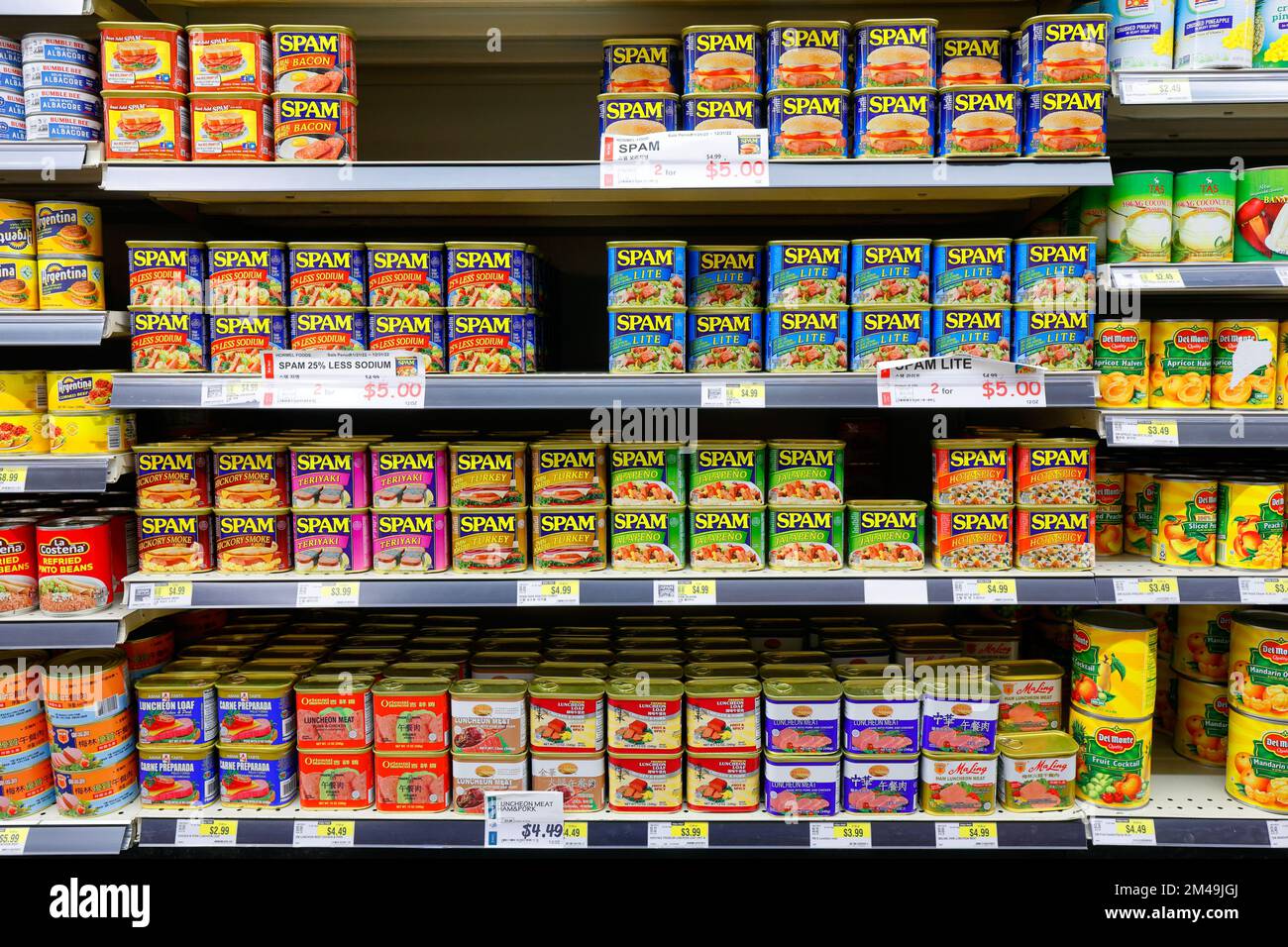 cans of Spam, various flavors of Spam, and other canned luncheon meat on a supermarket shelf. Stock Photo