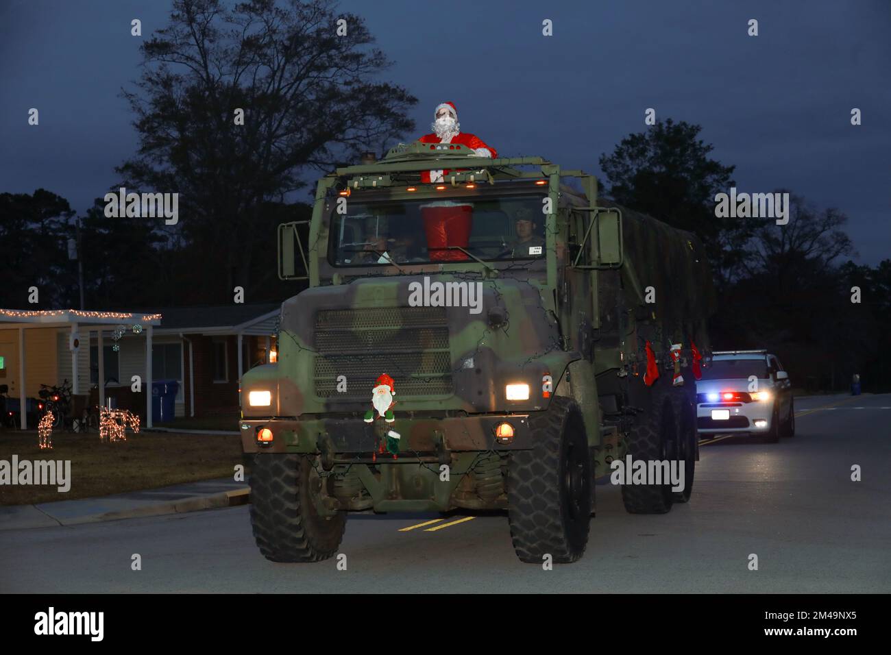 Santa rides in a medium tactical vehicle to wave to families on the street during the 3rd annual Christmas Parade, Marine Corps Air Station Cherry Point, North Carolina, Dec. 14, 2022. During the month of December, the 2D MAW Band parades through housing on the installation playing Christmas songs to spread festive cheer. (U.S. Marine Corps photo by Lance Cpl. Jade Farrington) Stock Photo