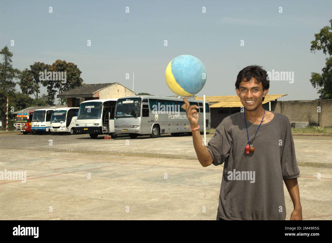 A young coach playing basketball at a basketball field that ...