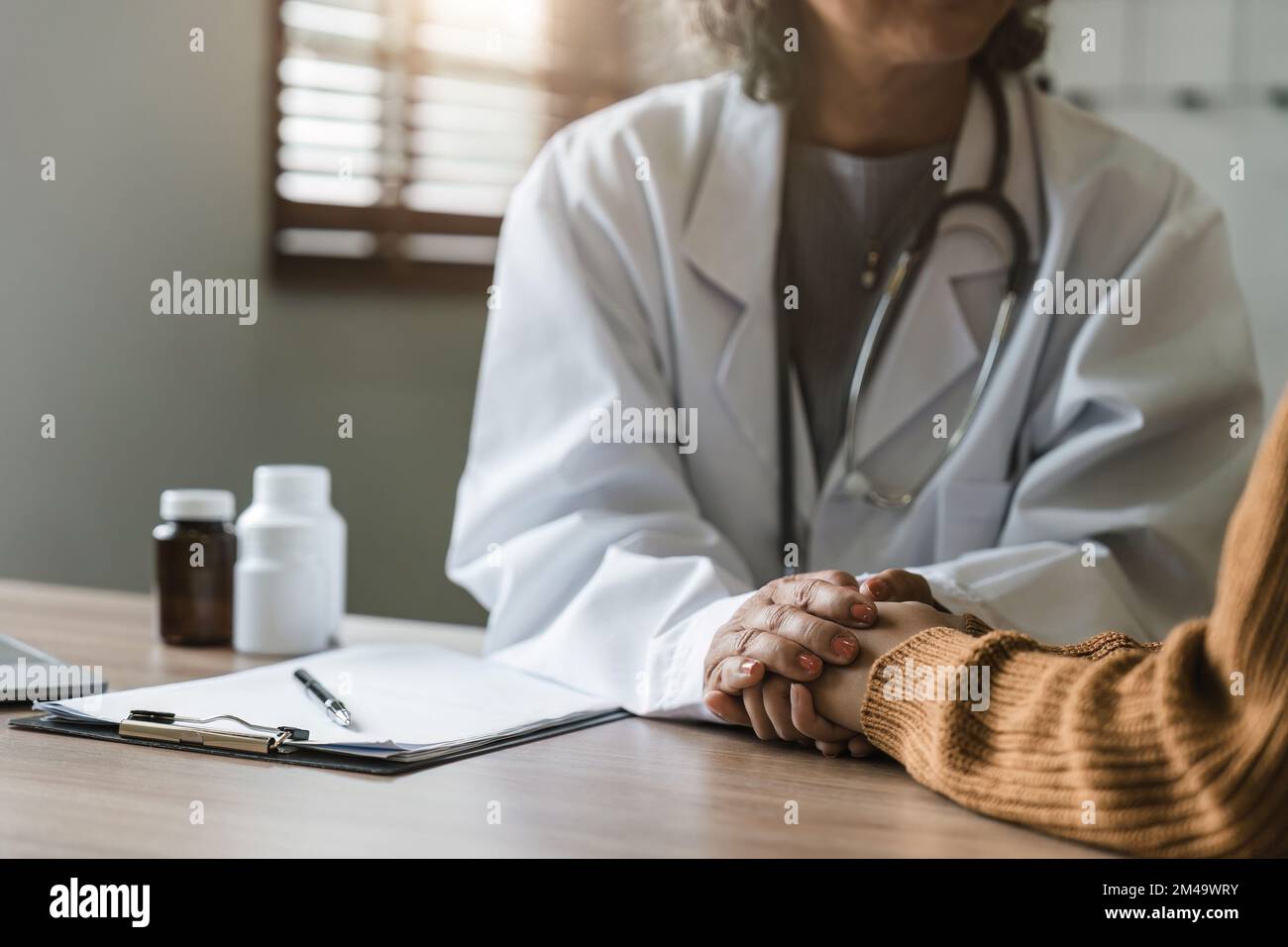Close up doctor hold hand of patient give comfort, express health care sympathy, medical help trust support encourage reassure infertile patient at Stock Photo