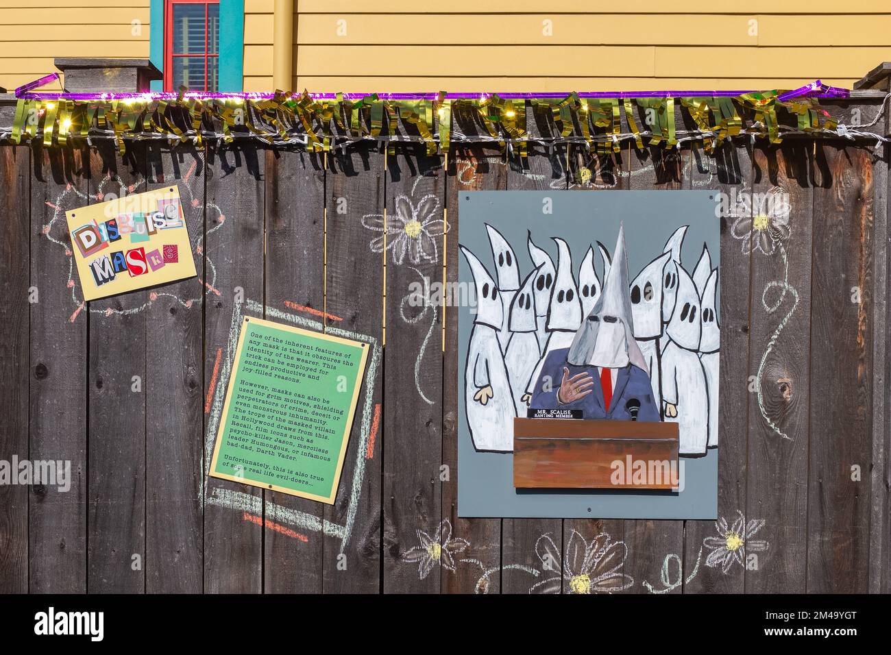 NEW ORLEANS, LA, USA - FEBRUARY 1, 2021: Fence decorated for Mardi Gras with artwork and information about masks and disguises  using political satire Stock Photo