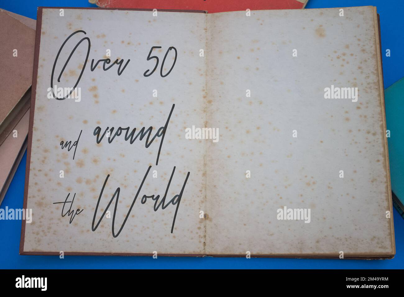 Over 50 and around the world word in opened book with vintage, natural ...