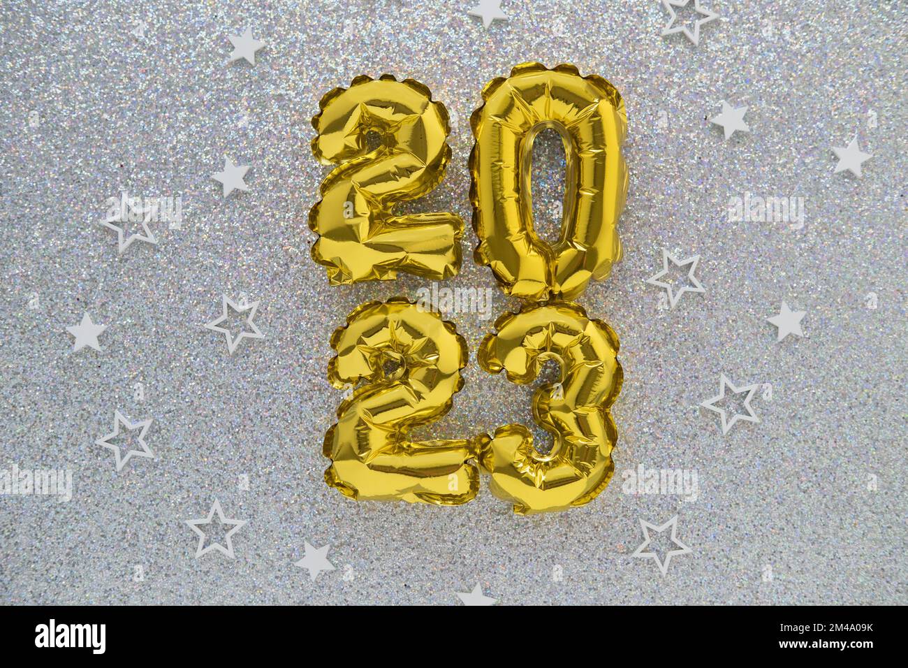 2023 gold foil balloons and confetti on silver glitter background. Festive concept. Stock Photo