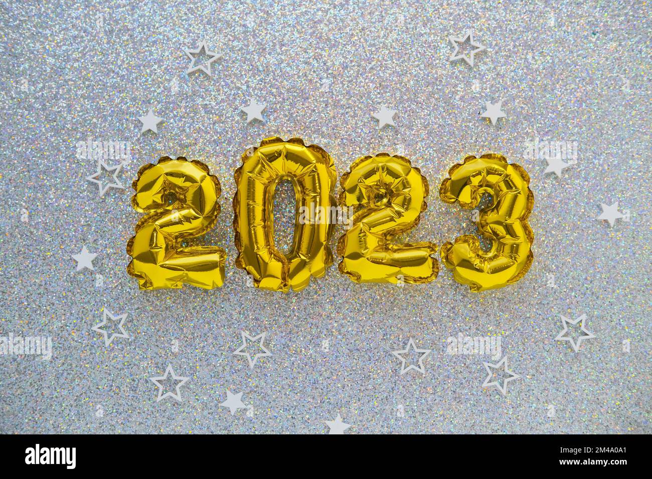 2023 gold foil balloons and confetti on silver glitter background. Festive concept. Stock Photo