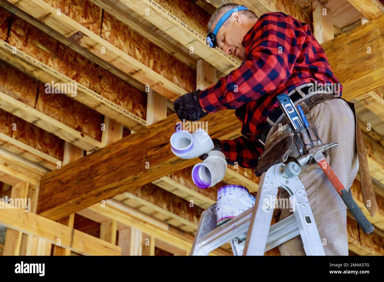 Plumber glues PVC plastic pipe with cement glue for purpose of joining
