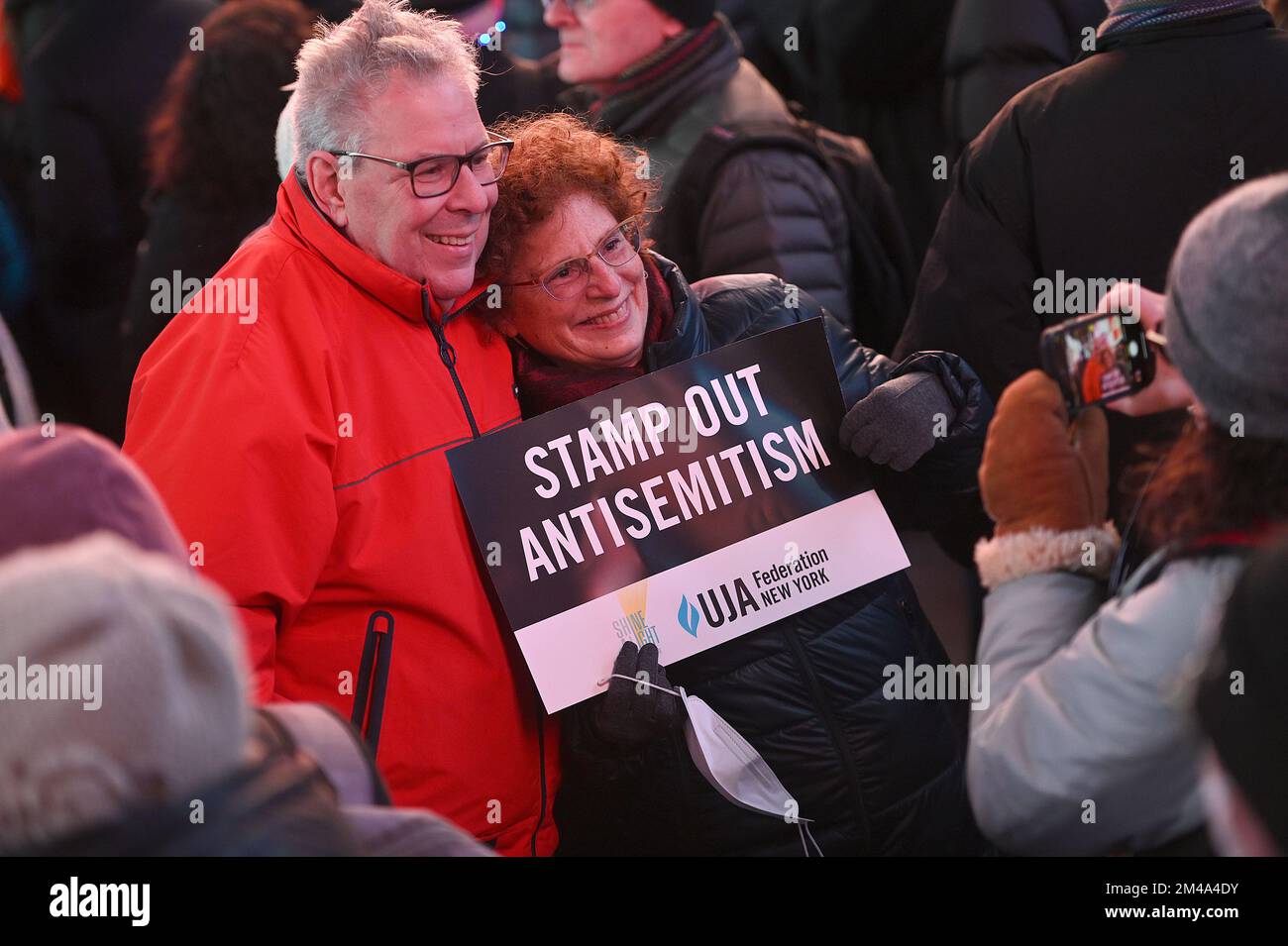 People pose with a sign denouncing antisemitism at the Shine A Light On ...