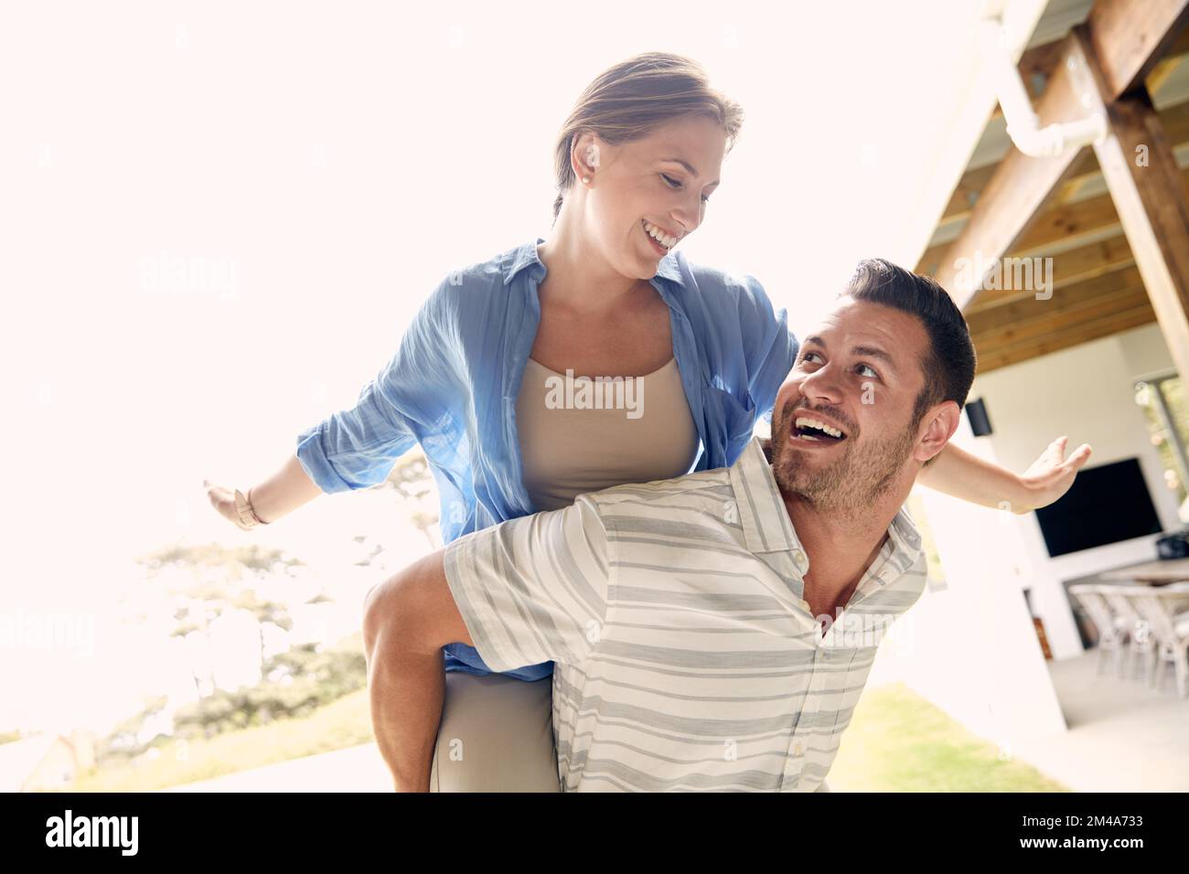 Man giving and adult woman a piggyback ride laughing and having fun in San  Diego, California. Stock Photo