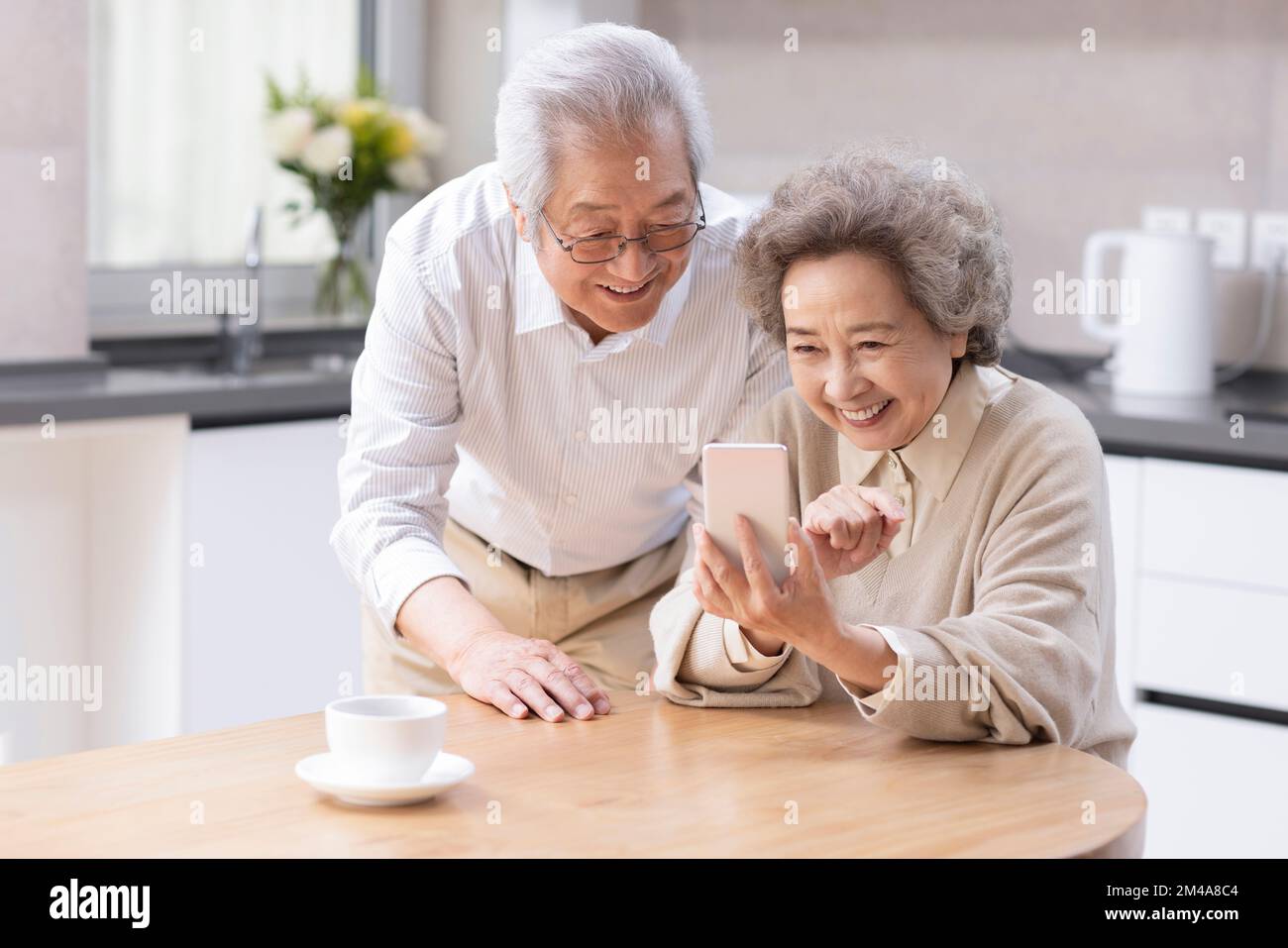 Senior Chinese couple  using smartphone at home Stock Photo