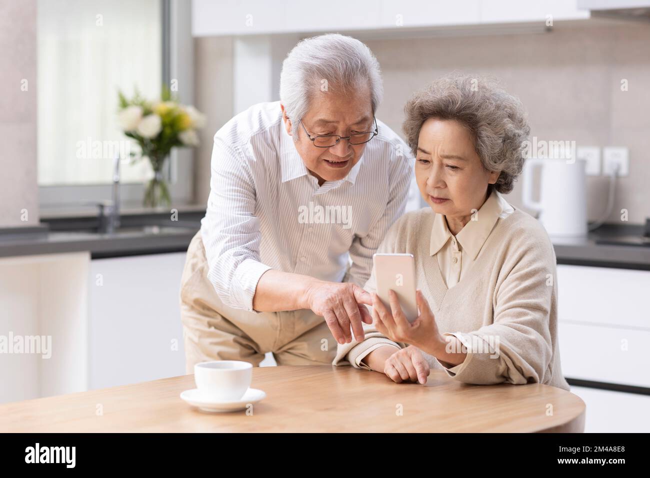 Senior Chinese couple  using smartphone at home Stock Photo