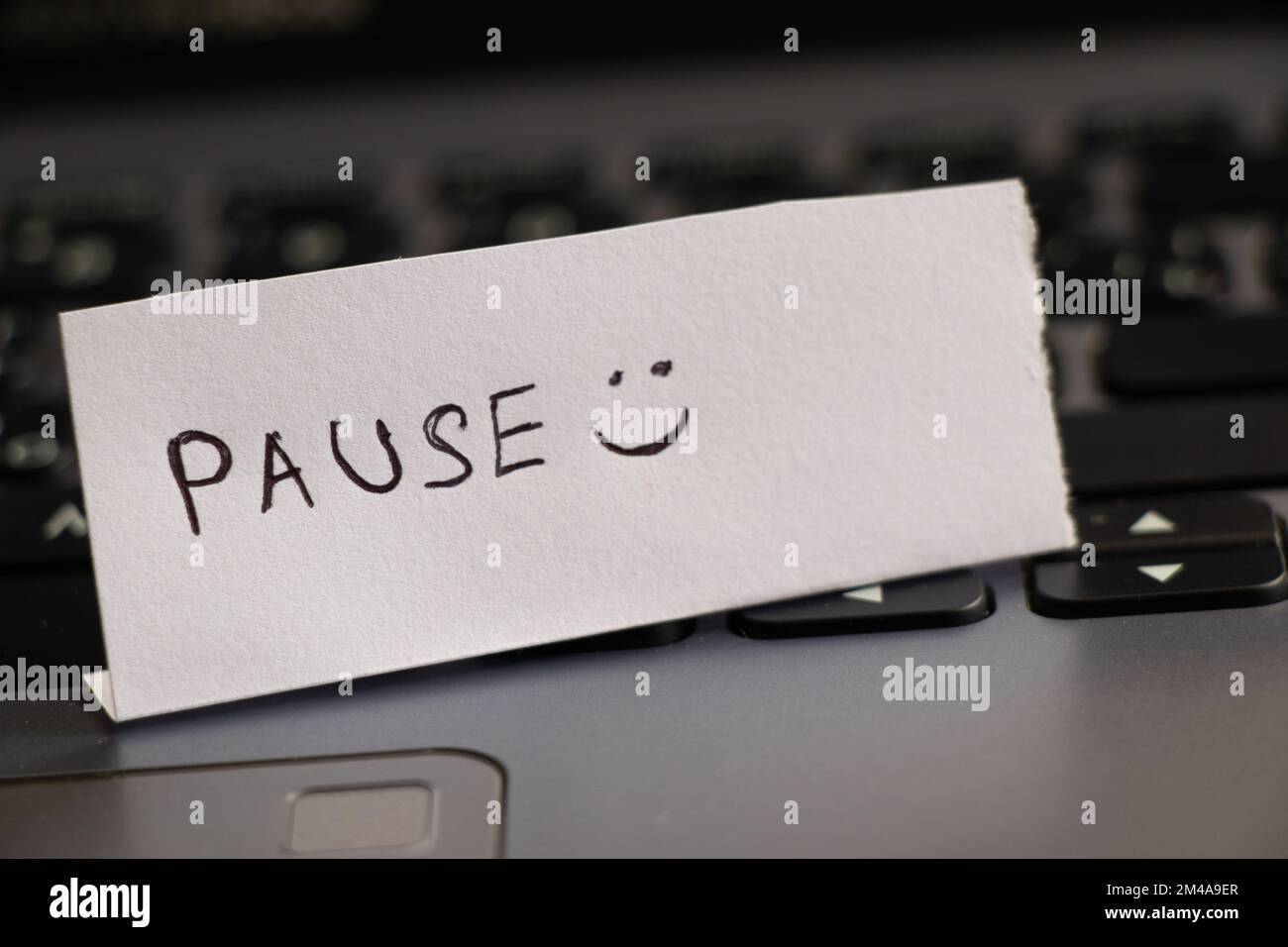 Pause and smiley handwritten on a piece of paper and left Stock Photo