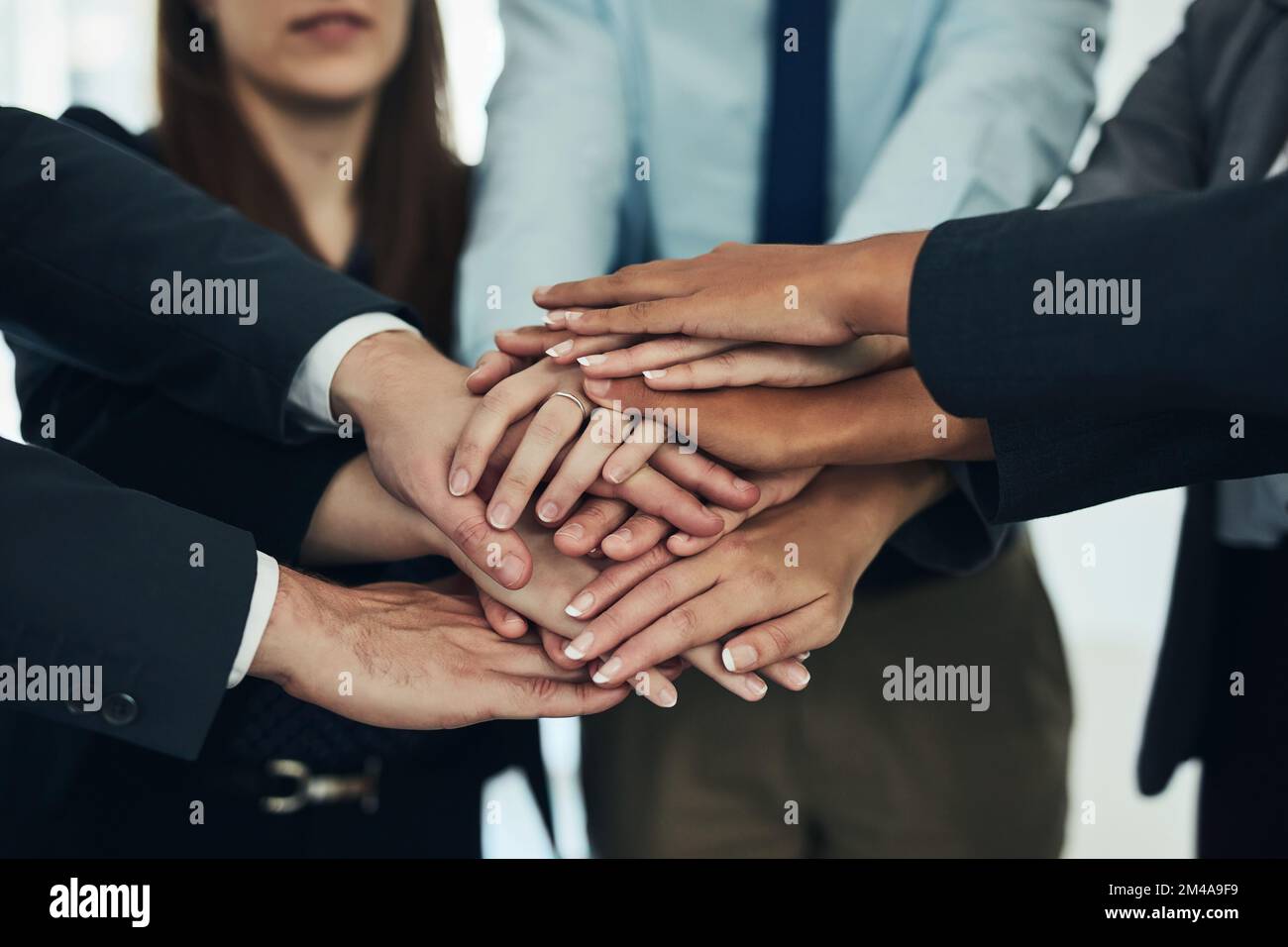 It takes a team to win in business. a group of businesspeople joining their hands in solidarity. Stock Photo